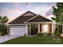 Charming single-Gathering home with a two-car garage, brick accents, and a well-manicured lawn at 562 Mountain View Dr, Monroe, NC 28110