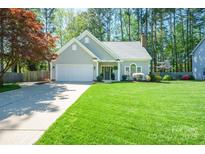 Charming single-story home with manicured lawn, two-car garage, and inviting front entrance at 8707 Copenhagen Ln, Charlotte, NC 28216
