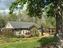Charming single-story home with metal roof, landscaped yard, and inviting outdoor deck perfect for relaxing at 179 Tomahawk Ln, Mount Gilead, NC 27371