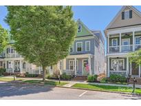 Charming blue two-story home with a welcoming front porch and American flag in a vibrant neighborhood at 275 Bridges Farm Rd, Mooresville, NC 28115