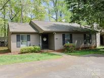 Charming single-story home with mature trees, green lawn, and cozy, inviting entrance at 380 Sweetgum Dr, Fort Mill, SC 29715