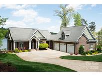 Stunning brick home with a three-car garage and a well-manicured front lawn near the water at 447 Shagbark Ct, Mount Gilead, NC 27306