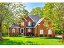 Traditional two-story brick home with manicured lawn and lush landscaping, offering timeless curb appeal at 5103 Trinity Trace Ln, Monroe, NC 28110