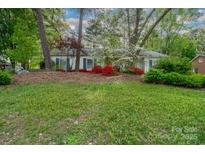 Charming home featuring a well maintained lawn and flowering azaleas lining the front of the house at 6815 Old Post Rd, Charlotte, NC 28212