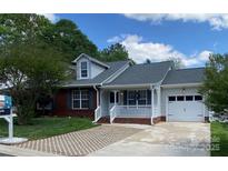 Charming single-story home features a brick and siding exterior, attached garage, and inviting front porch at 715 Cody Ct, Fort Mill, SC 29715