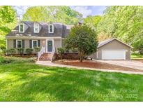 Charming home with a well-manicured lawn, complemented by a detached garage, enhancing its curb appeal at 7514 Pewter Ln, Charlotte, NC 28270