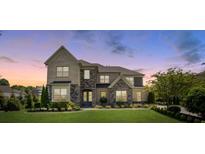 Beautiful two-story home featuring a manicured lawn, stone accents, and tasteful landscaping at 9611 Pensive Ln, Waxhaw, NC 28173