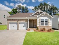 Charming single-story home with a brick facade, attached two-car garage, and well-manicured lawn at 1045 Cavalier Ln, Rock Hill, SC 29730
