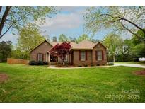 Charming single-story brick home with well-manicured lawn and mature landscaping creating a welcoming curb appeal at 115 Stumpy Creek Rd, Mooresville, NC 28117