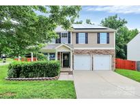 Inviting two-story home with stone accents, solar panels, and a well-manicured lawn at 1177 Ellis Pond Dr, Rock Hill, SC 29730