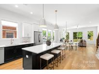 Modern kitchen featuring an island with seating, stainless steel appliances, and an open concept design at 2008 St John St, Charlotte, NC 28216