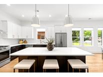 Bright, spacious kitchen with white cabinets, dark island and stainless steel appliances at 2008 St John St, Charlotte, NC 28216