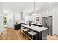 Modern kitchen featuring an island with seating, stainless steel appliances, and stylish pendant lighting at 2008 St John St, Charlotte, NC 28216