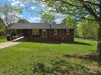Charming one-story brick home with a well-maintained lawn and a covered carport on a sunny day at 205 Cooke Cir, Kings Mountain, NC 28086