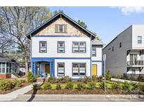 Charming two-story home featuring colorful accents, a welcoming porch, and fresh landscaping at 210 Walford Dr, Charlotte, NC 28208