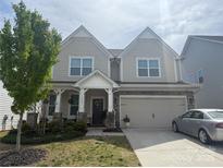 Charming two-story home features a covered porch, two-car garage, and well-maintained landscaping at 3042 Burnello Ct, Iron Station, NC 28080