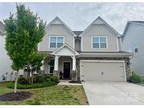 Charming two-story home with stone accents, a well-manicured lawn, and a two car garage at 3042 Burnello Ct, Iron Station, NC 28080