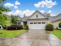 Inviting single-story home with a well-manicured lawn, mature shrubs, and an attached two-car garage at 527 Livingston Dr, Lancaster, SC 29720