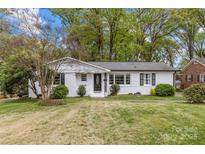 Charming white-brick ranch-style home with a well-manicured lawn and mature trees, offering classic curb appeal at 6127 Rosecrest Dr, Charlotte, NC 28210