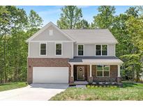 Charming two-story home with a brick facade, attached garage, and a well-manicured front lawn at 8937 Penstemons Dr, Charlotte, NC 28215