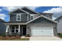 Charming two-story home features a stone facade, carriage garage door, and stylish gray shingle siding at 1216 Morehead Dr, Salisbury, NC 28144