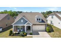 Charming home with stone accents, covered porch, and well-manicured lawn in a beautiful residential neighborhood at 15710 Oleander Dr, Charlotte, NC 28278