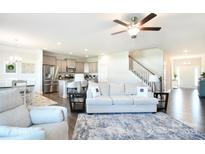 Open-concept living room showcasing a seamless flow to the modern kitchen and staircase at 221 Mountain Island Dr, Statesville, NC 28677