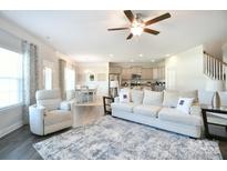Open-concept living room featuring hardwood floors and neutral tones connects to kitchen and dining area at 221 Mountain Island Dr, Statesville, NC 28677
