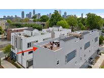 An aerial view of the modern townhome exteriors with a rooftop patio and the Charlotte skyline in the background at 310 Wesley Heights Way, Charlotte, NC 28208