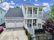 Inviting two-story home with a spacious double porch, three-car garage, and well-manicured landscaping at 374 Horton Grove Rd, Fort Mill, SC 29715