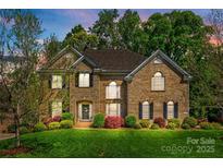 Beautiful two-story brick home with a well-manicured lawn and colorful landscaping at 405 Five Leaf Ln, Waxhaw, NC 28173