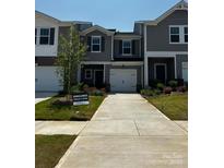 New construction townhome features a one-car garage, neutral paint, and manicured landscaping at 4305 Summit Woods Dr, Charlotte, NC 28216