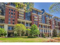 Stunning brick condominium building with balconies, lush landscaping, and verdant lawn area on a sunny day at 435 S Tryon St, Charlotte, NC 28202