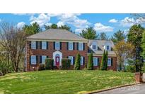 Traditional two-story brick home with a manicured lawn and symmetrical design, accented by dark green shutters at 4405 3Rd Nw St, Hickory, NC 28601