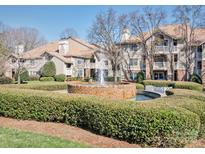 Beautiful condo community featuring lush landscaping, water fountain, and inviting residential buildings on a sunny day at 5007 Sharon Rd # R, Charlotte, NC 28210