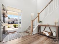 Bright foyer with wood floors, staircase, and a view of the neighborhood through the front door at 5532 Muckross Ln, Fort Mill, SC 29707