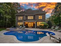 Stunning backyard features a large pool, spa, and outdoor seating area, perfect for entertaining and relaxation at 1717 Brawley School Rd, Mooresville, NC 28117