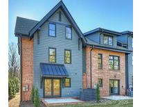 Two-story exterior showcasing a blend of blue siding and brick with a covered entryway, reflecting modern design at 2027 Thurmond Pl, Charlotte, NC 28205
