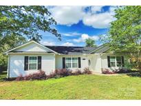 Charming single-story home with white siding, black shutters, and a well-maintained front yard with lush landscaping at 252 S Potter Rd, Lancaster, SC 29720