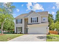 Charming two-story home with a well-maintained lawn, two car garage, and classic architectural details at 3831 Robeson Creek Dr, Charlotte, NC 28270