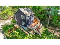 View of the back of the home with a large wooden deck and a lush green lawn at 4036 Windward Dr, Tega Cay, SC 29708