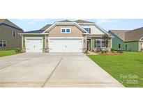 Inviting two-story home featuring a three-car garage, beautiful landscaping, and a well-manicured lawn at 4110 Camden Glen Rd, Lancaster, SC 29720