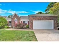 Charming brick home featuring a two-car garage and a well-maintained front yard at 4155 Guilford Nw Ct, Concord, NC 28027