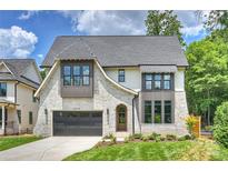 Beautiful home featuring light brick, a dark gray roof, a two car garage, and a manicured front lawn at 5010 Ohm Ln, Charlotte, NC 28270