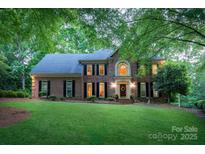 Charming two-story brick home with a lush lawn and mature trees. Beautiful entryway with classic architectural details at 6017 Summerston Pl, Charlotte, NC 28277