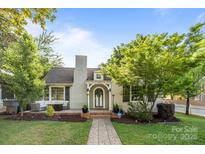 Charming home with brick walkway, front porch, well-manicured lawn, and mature landscaping under a bright blue sky at 700 Oakland Ave, Charlotte, NC 28204