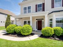 Charming home with a welcoming front porch, landscaped yard, and beautiful curb appeal on a sunny day at 79411 Ridgehaven Rd, Indian Land, SC 29720
