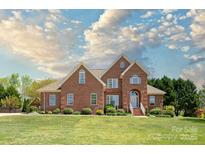 Charming two-story brick home featuring a manicured lawn and professionally landscaped garden beds at 1103 Hillcrest Ridge Dr, Salisbury, NC 28146