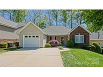 Charming single-story home with a well-maintained front yard, attached garage, and inviting entrance at 115 Keswick Ln, Mooresville, NC 28117