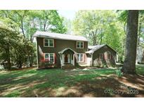 Charming two-story home with a well-manicured lawn, mature trees, and quaint red shutters, blending comfort and curb appeal at 1174 Orchard Dr, Fort Mill, SC 29715